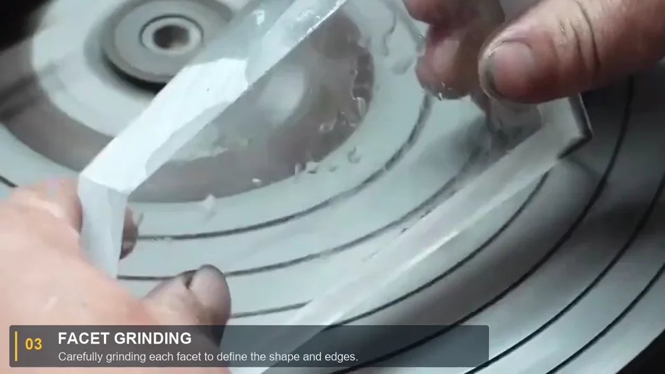 A worker holding a crystal piece against a grinding wheel