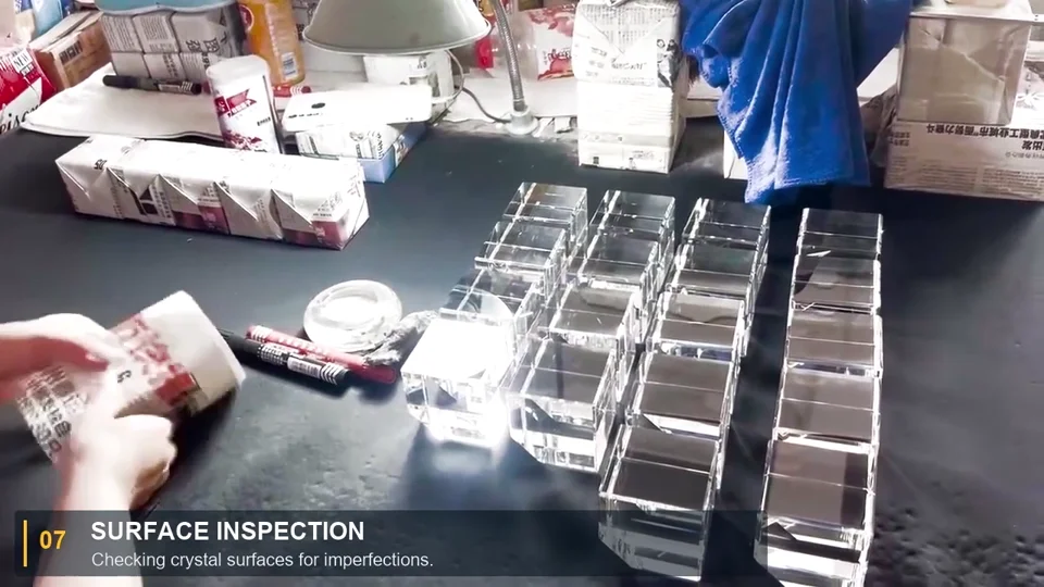 A worker examining a crystal piece beside rows of crystal blanks